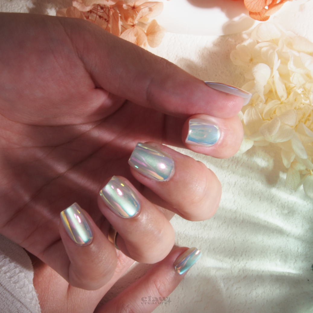 Sea Breeze Iridescent Handmade Press-on Nails display on hand by Claw Creature